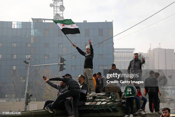 People react to the fall of Syrian regime in Umayyad Square on December 8, 2024 in Damascus, Syria. Rebel forces in Syria claimed that they had...