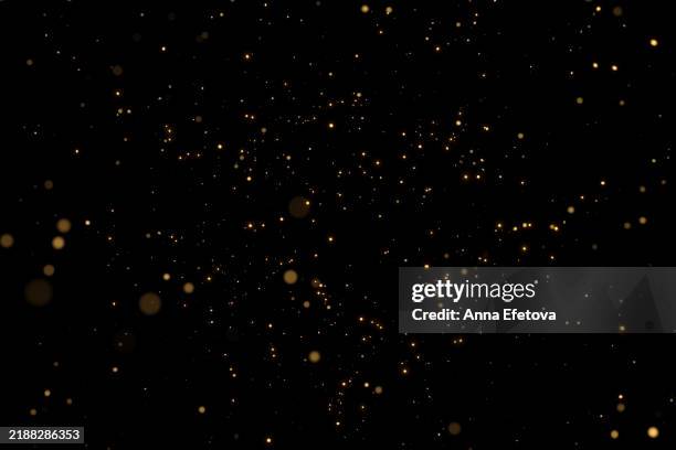 many festive blurred golden confetti on black background. concept of new year or birthday celebration. perfect backdrop for your design - purpurina fotografías e imágenes de stock