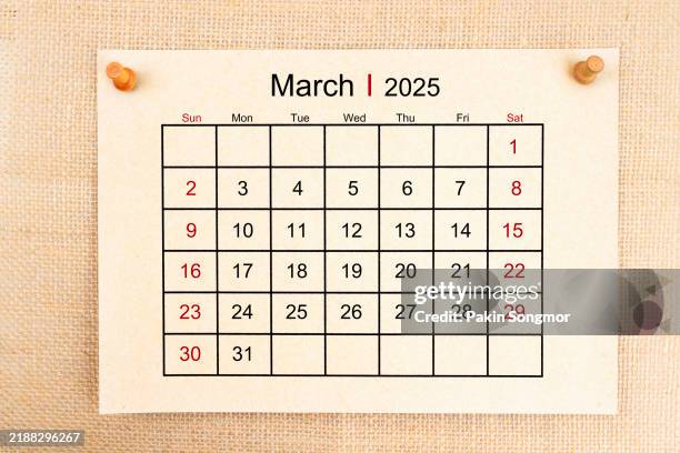 desk calendar 2025: march card calendar is used to plan daily work and life with a push pin on burlap background. - marzo fotografías e imágenes de stock