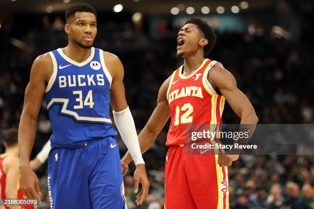 De'Andre Hunter of the Atlanta Hawks reacts to a score in front of Giannis Antetokounmpo of the Milwaukee Bucks during the second half of a game at...