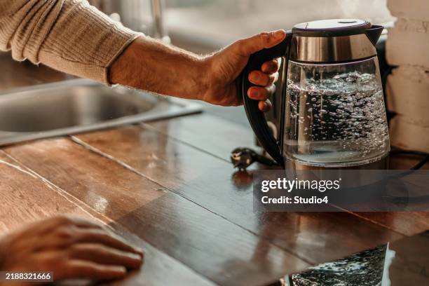 bollitore con acqua bollente - bollente foto e immagini stock