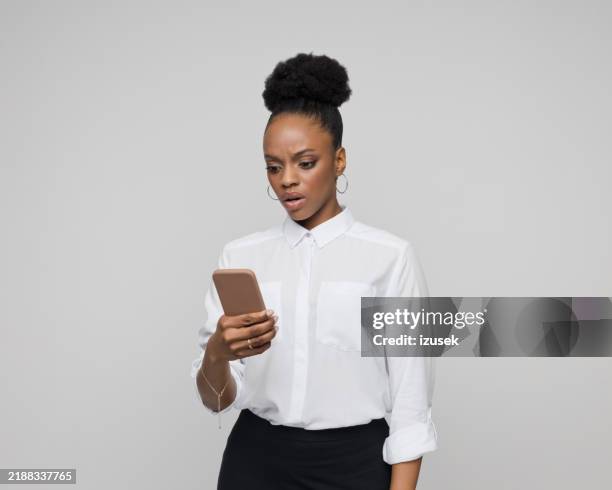 portrait of worried young businesswoman using phone - shock stock pictures, royalty-free photos & images