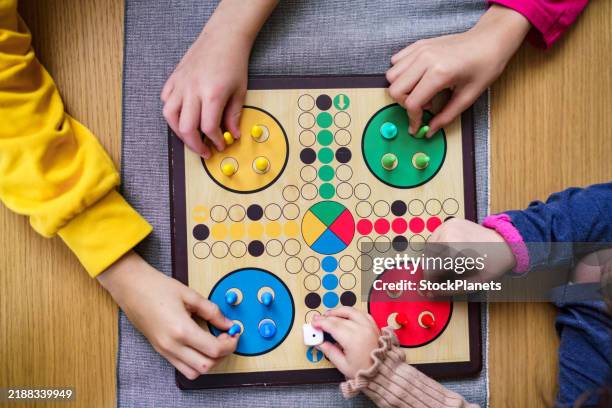 las manos de los niños se preparan para el juego del parchís - jugar fotografías e imágenes de stock