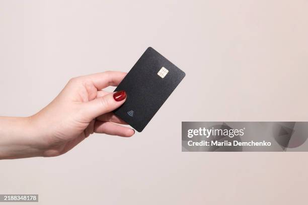 female hand with black credit card - mano umana foto e immagini stock