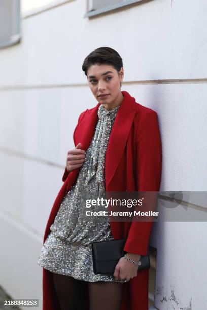 Sarah Posch is seen wearing a calf-length red coat with peak lapels from Liu Jo; a sparkling silver New Year's Eve mini dress covered in sequins,...