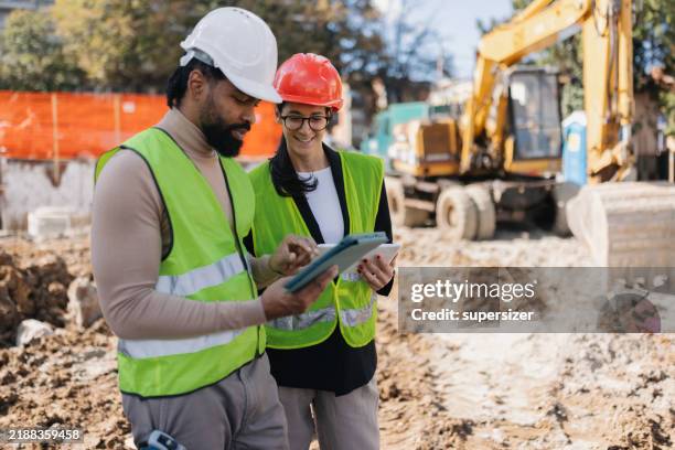 constructive conversation over project plans - construction-worker stockfoto's en -beelden