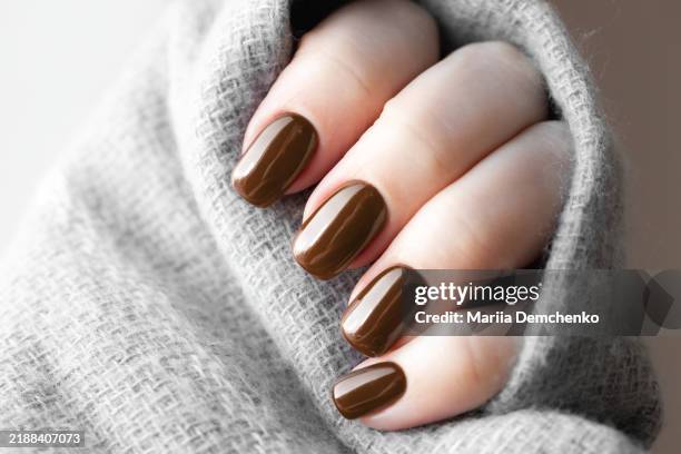 hand with brown, mocha color gel fingernails - manicure stockfoto's en -beelden