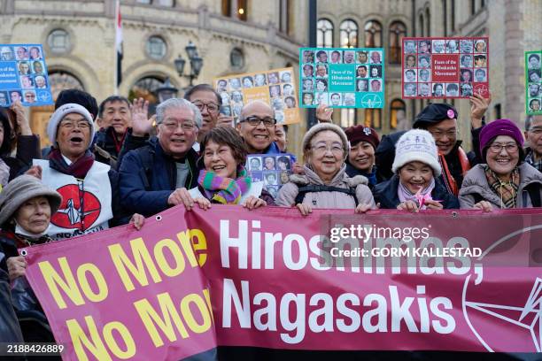 People pose with a banner against nuclear weapons as activists of the 2017 Nobel Peace Prize winning International Campaign to Abolish Nuclear...