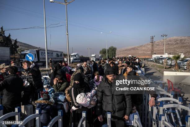 Syrian refugees who lives in Turkey wait in a queue at Cilvegozu crossborder gate before entering Syria at Reyhanli district in Hatay, on December 9,...