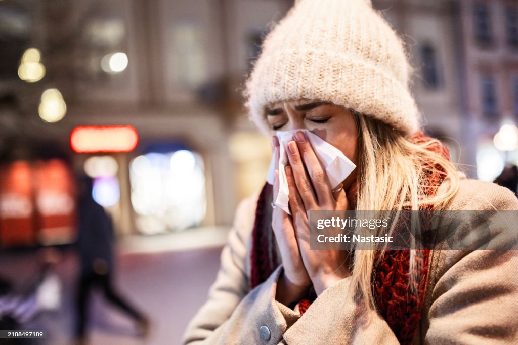 Young Woman Fighting a Cold While Walking Outside