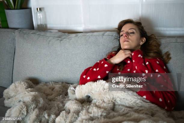 sick young woman resting on sofa at home - sore throat stock pictures, royalty-free photos & images