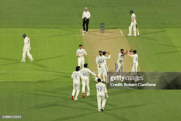 Jasprit Bumrah of India celebrates with teammate Nitish Kumar Reddy of India after dismissing Usman Khawaja of Australia as he leaves the field...