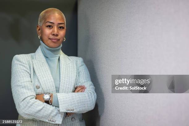 confident woman standing with arms folded - blue blazer stock pictures, royalty-free photos & images