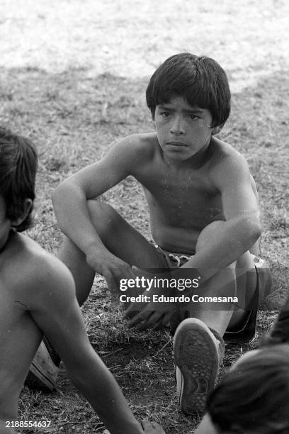 View Argentine soccer player Diego Maradona of Los Cebollitas junior team as he sits on the ground, Buenos Aires, Argentina, 1973.