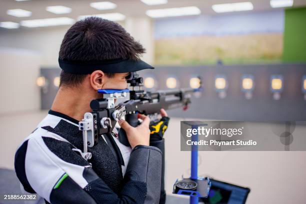precision shooting athlete at an indoor range - espingarda imagens e fotografias de stock