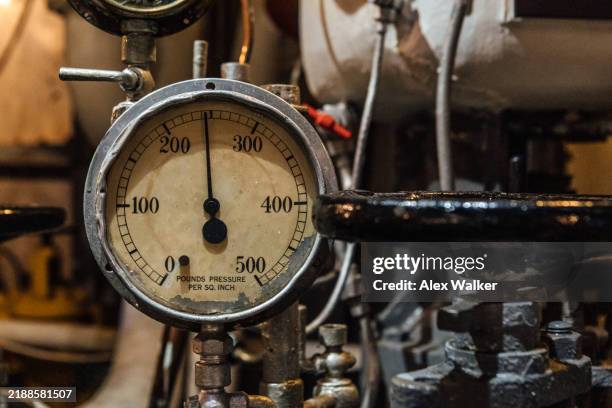 pressure gauge surrounded by pipes and valves - druckmesser stock-fotos und bilder