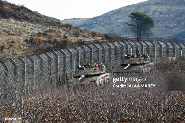 Israeli military vehicles are stationed close to the Druze village of Majdal Shams, by the fence separating the Israel-annexed Golan heights and a...