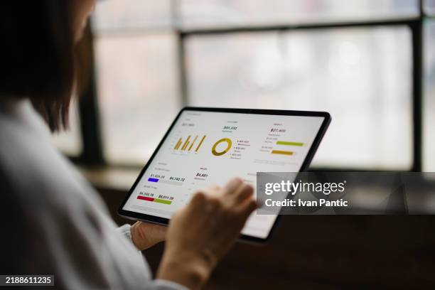close up of woman analyzing business data on tablet in modern office space - financial literacy stock pictures, royalty-free photos & images