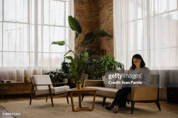 professionelle frau, die am tablet im modernen büro-lounge-bereich arbeitet - komfortzone stock-fotos und bilder