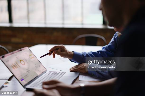 kollegen, die in einem modernen büro an der datenanalyse zusammenarbeiten - data science stock-fotos und bilder