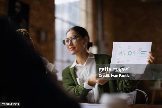 mujer de negocios que presenta informe financiero en un entorno de oficina moderno - informe financiero fotografías e imágenes de stock