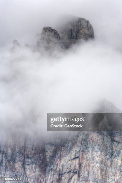 low clouds drift amid coastal cliffs of granite - rock face stock pictures, royalty-free photos & images
