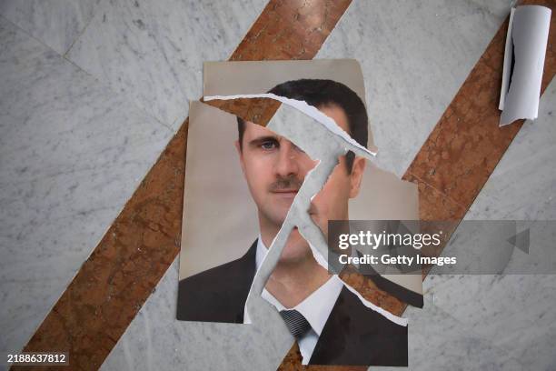 Torn portrait of Bashir al-Assad, that appears to have been arranged, is seen inside the Presidential Palace on December 10, 2024 in Damascus, Syria....