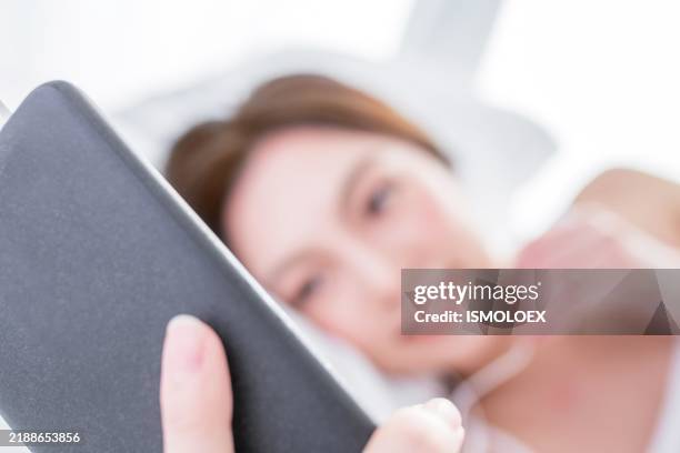 asian woman using smartphone in bed - young model forum stock pictures, royalty-free photos & images