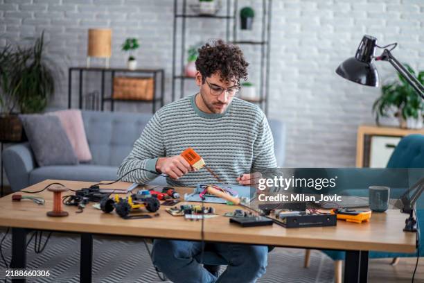 man soldering elements on circuit board - electrical equipment stock pictures, royalty-free photos & images
