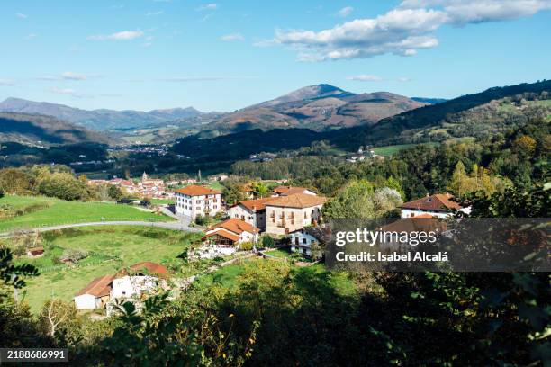 picturesque rural village surrounded by mountains and green fields - navarra stock pictures, royalty-free photos & images
