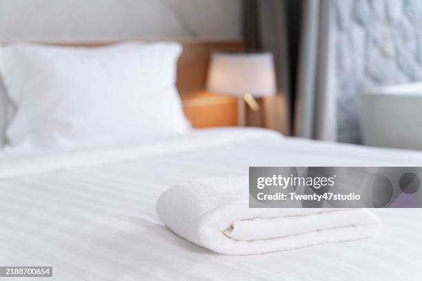a cropped shot of an arranged towel on the bed in a hotel bedroom - hotel room foto e immagini stock