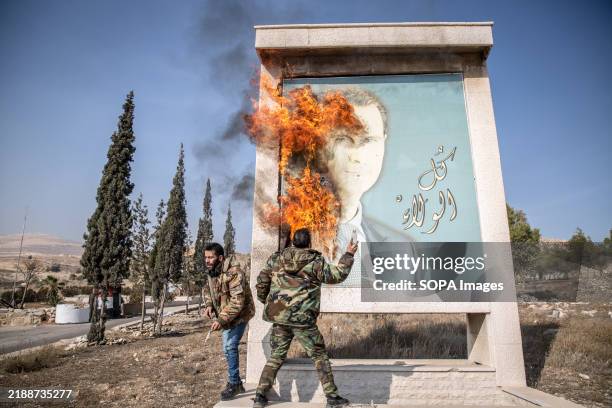 Man burns a picture of former Syrian president Bashar al-Assad close to Syria's border with Lebanon. Rebels launched a shock offensive across Syria...
