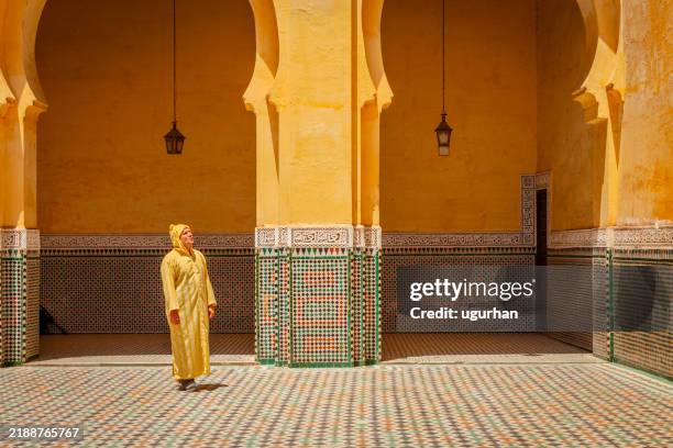 man walking in the mausoleum of moulay ismail in meknes, morocco - meknes stock pictures, royalty-free photos & images