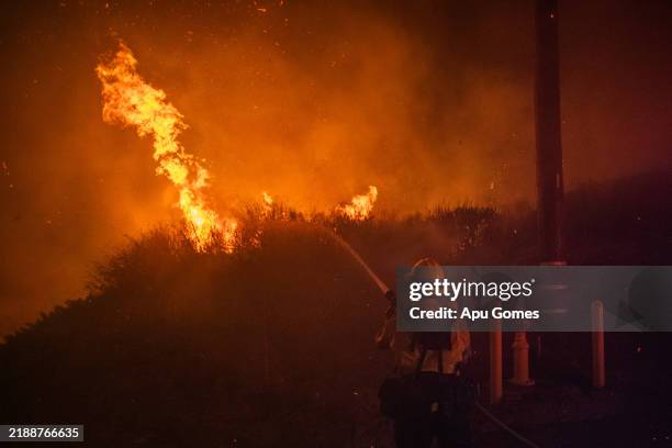 Firefighter battles the flames of the Franklin Fire while it burns in the Pacific Coast Highway in the morning on December 11, 2024 near Malibu,...