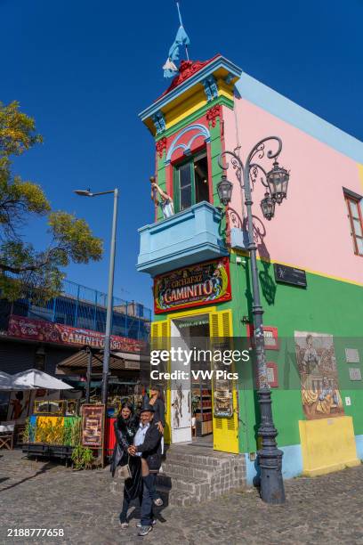 Tourist poses for a photo with a tango dancer on Caminito in La Boca, Buenos Aires, Argentina.