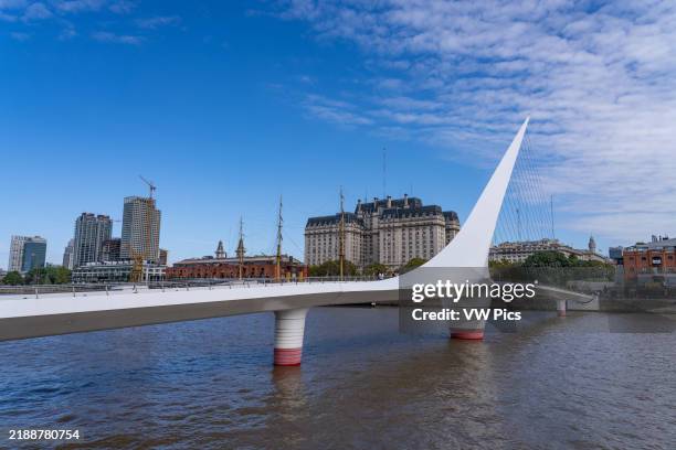La Puente de la Mujer or the Woman's Bridge over Dock 3 in Puerto Madero, Buenos Aires, Argentina. Behind is the Libertador Building, headquarters of...
