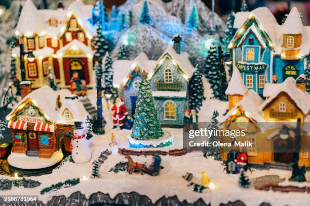 festive miniature christmas village scene with snow and decorations - décembre photos et images de collection
