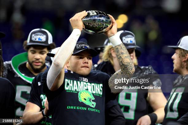 Dillon Gabriel of the Oregon Ducks celebrates with the trophy after the team's 45-37 win against the Penn State Nittany Lions in the 2024 Big Ten...