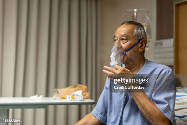 elderly senior man wear oxygen inhaler device for helping breath respiratory. patient use portable oxygen at hospital. patients with respiratory disorders. portable oxygen concentrator or oxygen generator - nebulizer stock pictures, royalty-free photos & images