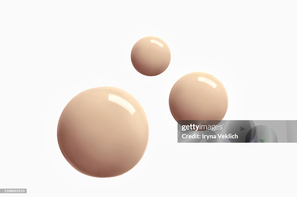 Three Round Shape Drops of Thick Make-up Face Foundation falling from Pipette on white background. Concept Trendy Color of the Year 2025 Mocha Mousse Beige and Brown.
