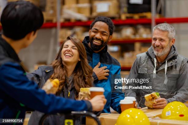 des employés d’entrepôt multiculturels rient et se détendent pendant la pause déjeuner - ouvrier photos et images de collection
