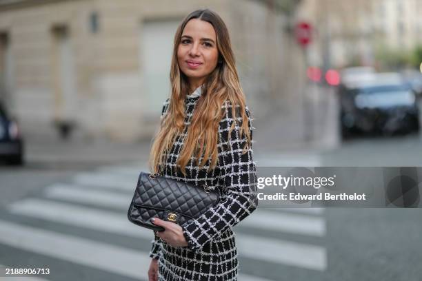 Maria Rosaria Rizzo wears a black and white tweed jacket, a black leather Chanel bag, during a street style fashion photo session, on November 30,...