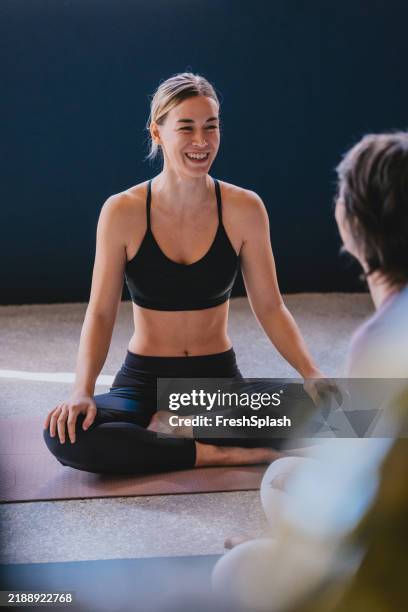 smiling woman practicing yoga in a relaxing studio environment - yoga pants stock pictures, royalty-free photos & images