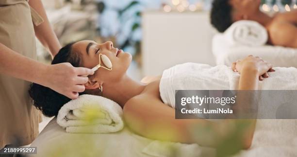 spa, donna e occhi chiusi con rullo per massaggi di lusso, cura di sé e sollievo dallo stress. cura della pelle, persona femminile e cliente con massaggiatrice o terapista per trattamenti viso, zen o benessere in resort - centro benessere stabilimento termale foto e immagini stock
