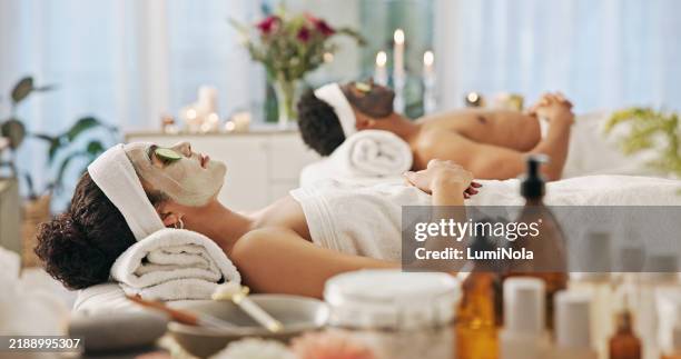 woman, rest and cucumber with face mask at spa for facial treatment, cosmetic skincare and dermatology. couple, relax and clay product for collagen, holistic healing self care of beauty glow at hotel - spa bildbanksfoton och bilder