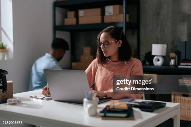 female ecommerce volunteer working on a laptop - coordinator stock pictures, royalty-free photos & images