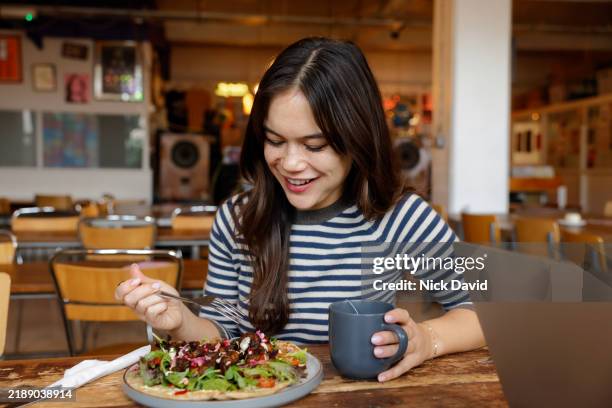 a young woman eating a healthy lunch in a cafe - eating stock pictures, royalty-free photos & images