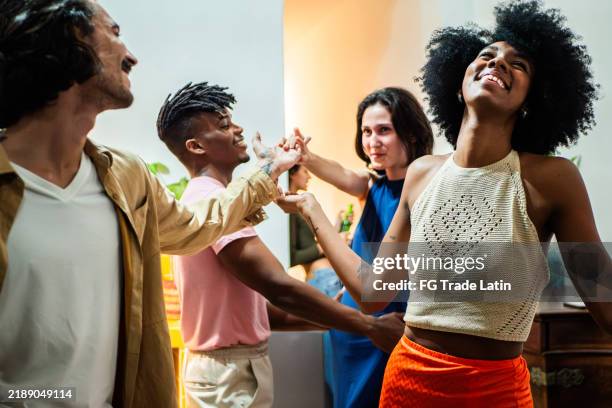 young friends talking and dancing at home - cuban house stock pictures, royalty-free photos & images
