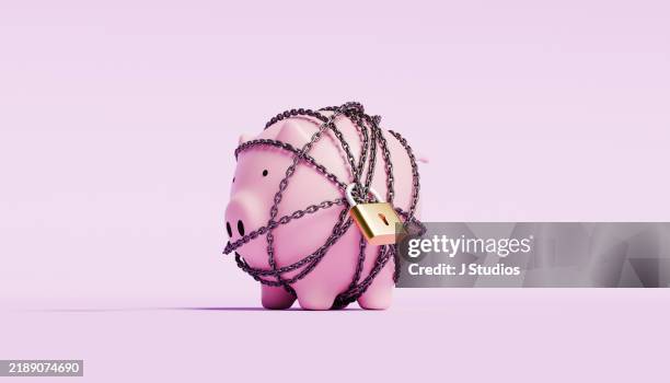 piggy bank wrapped in a chain with a lock - stuck stock pictures, royalty-free photos & images