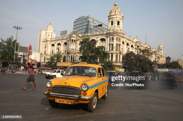 An iconic yellow Ambassador taxi crosses the road junctions in Kolkata, India, on December 13, 2024. The Calcutta High Court orders that Kolkata's...